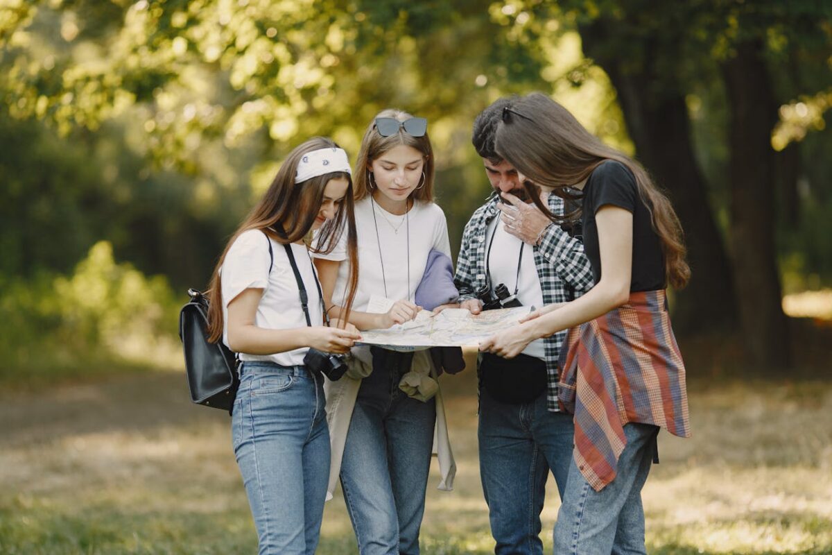A diverse group of friends navigating with a map in a sunlit park.